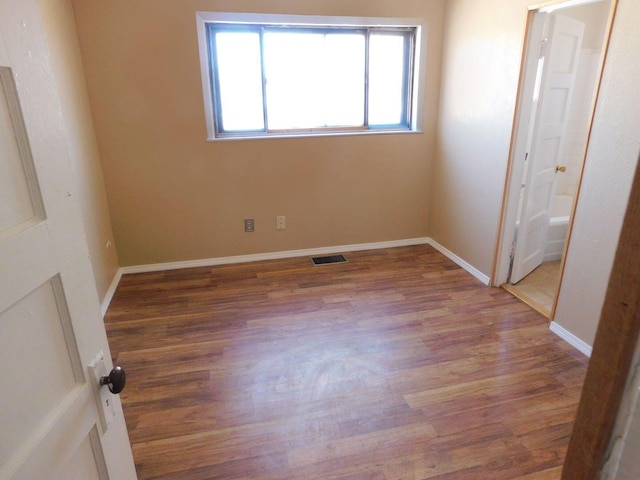 unfurnished bedroom with baseboards, visible vents, and wood finished floors