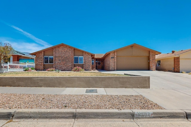 single story home with driveway, fence, an attached garage, and brick siding