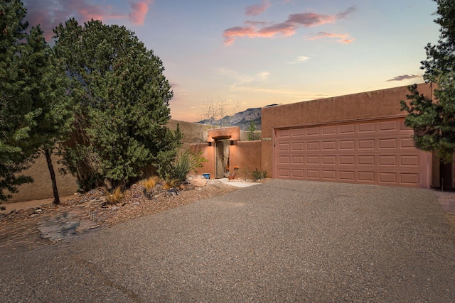 garage at dusk with aphalt driveway