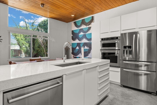 kitchen featuring light stone countertops, a sink, stainless steel appliances, white cabinetry, and wooden ceiling