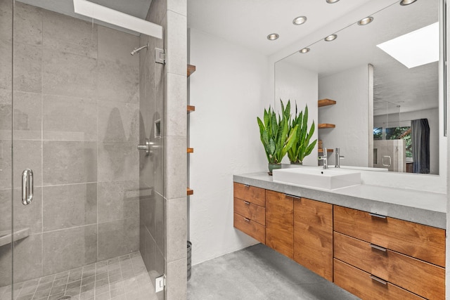 bathroom featuring finished concrete floors, a skylight, a stall shower, vanity, and recessed lighting