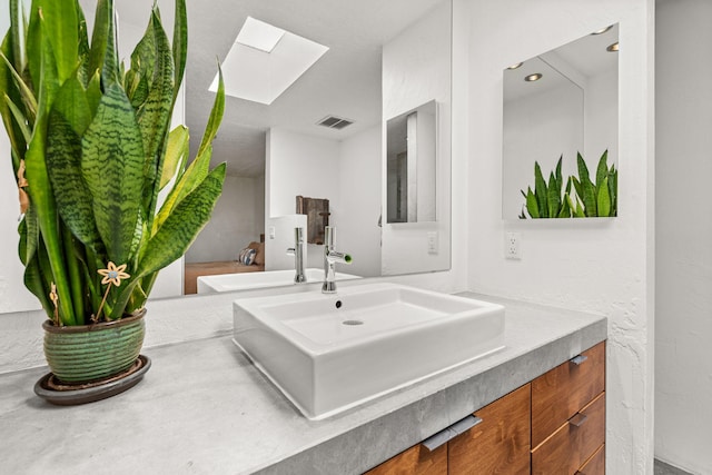 bathroom with visible vents, a skylight, and vanity