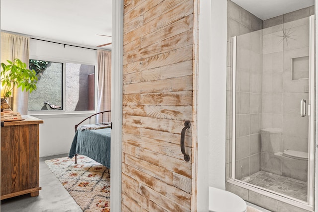 ensuite bathroom with ensuite bathroom, concrete flooring, a stall shower, and toilet