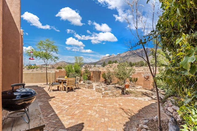 view of patio with a fenced backyard, a mountain view, and outdoor dining space