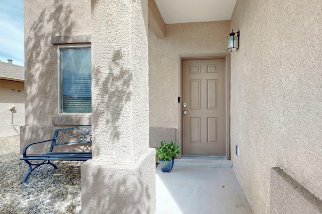 property entrance with stucco siding