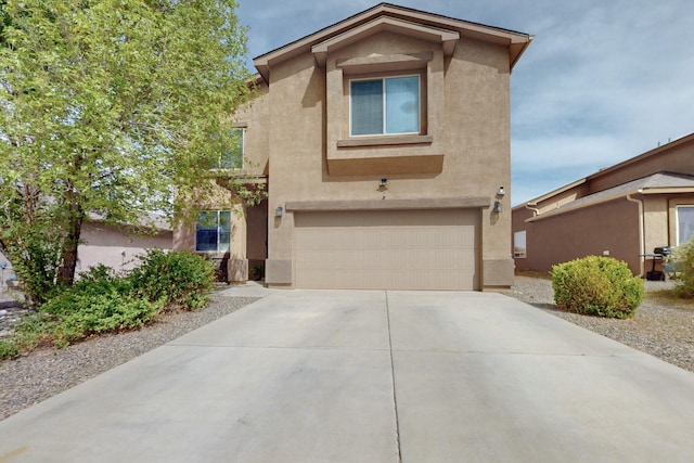traditional home with stucco siding, driveway, and an attached garage