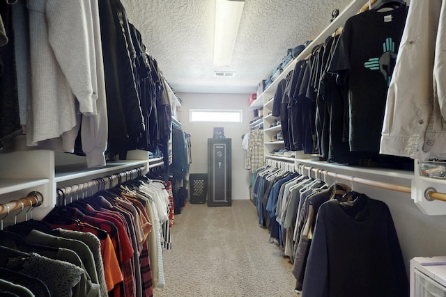 walk in closet featuring visible vents and light carpet