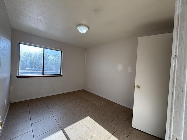 unfurnished room featuring tile patterned floors and baseboards