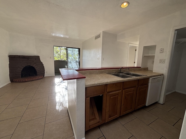 kitchen featuring a sink, light tile patterned floors, white dishwasher, visible vents, and open floor plan