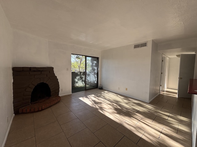 unfurnished living room featuring a fireplace with raised hearth, visible vents, tile patterned floors, and baseboards