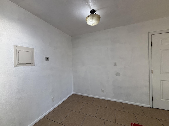 tiled empty room featuring baseboards