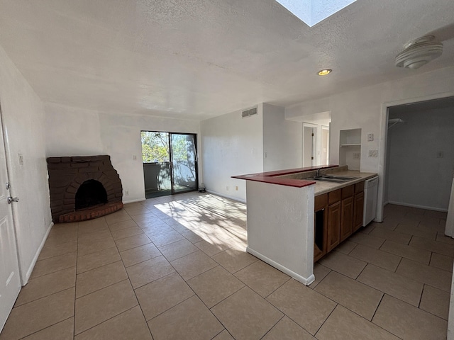 kitchen featuring light tile patterned floors, a sink, visible vents, and open floor plan