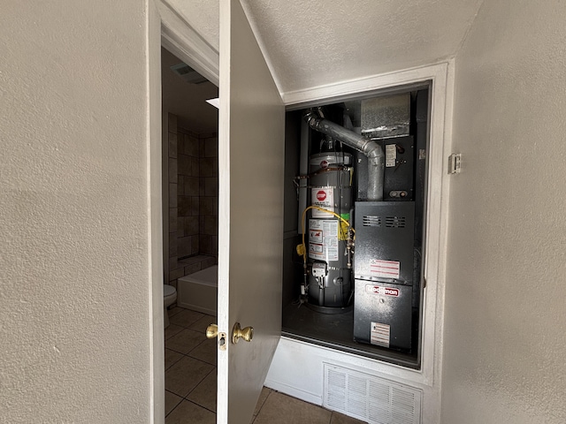 utility room with water heater and visible vents