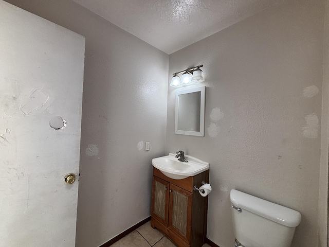 half bath featuring tile patterned floors, toilet, and vanity