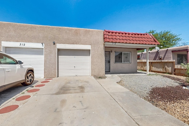 308 Garden Ave SW, Los Lunas, NM 87031 - view of front of property featuring a tiled roof, fence, concrete driveway, and stucco siding