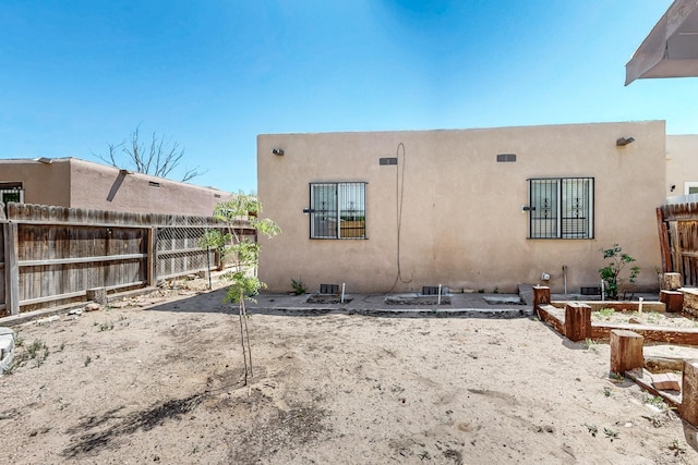 308 Garden Ave SW, Los Lunas, NM 87031 - rear view of house with a fenced backyard, stucco siding, and a garden