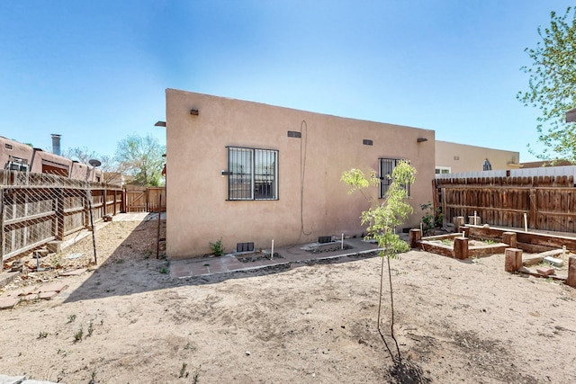 308 Garden Ave SW, Los Lunas, NM 87031 - back of house featuring a fenced backyard, stucco siding, and a garden