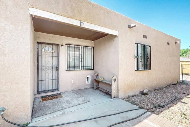 308 Garden Ave SW, Los Lunas, NM 87031 - view of exterior entry featuring fence and stucco siding