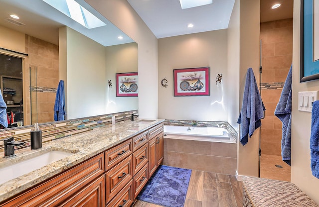 3919 Bryan Ave NW, Albuquerque, NM 87114 - full bath featuring a skylight, a bath, double vanity, and tiled shower