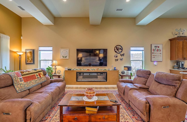 3919 Bryan Ave NW, Albuquerque, NM 87114 - living area with a glass covered fireplace, healthy amount of natural light, beam ceiling, and recessed lighting