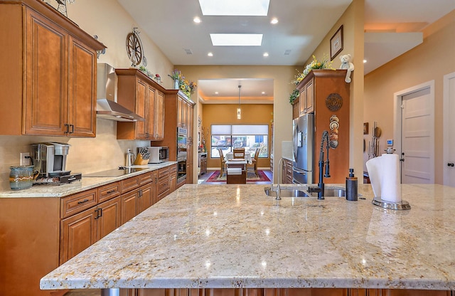 3919 Bryan Ave NW, Albuquerque, NM 87114 - kitchen featuring wall chimney exhaust hood, brown cabinetry, appliances with stainless steel finishes, light stone countertops, and decorative backsplash