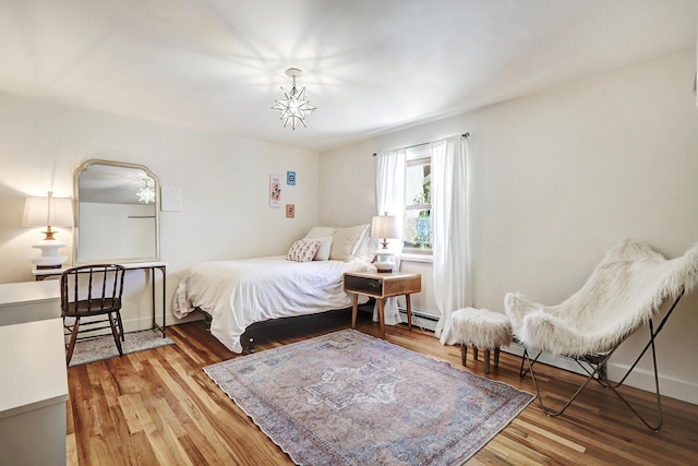 107 Rome Ln, Corrales, NM 87048 - bedroom with wood finished floors and a baseboard heating unit