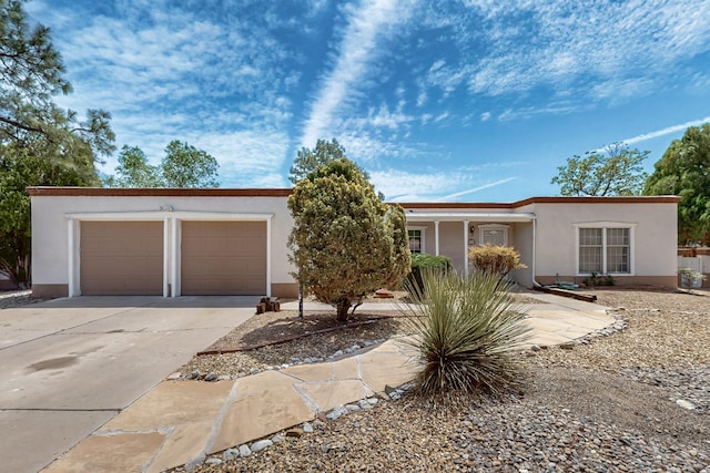 single story home featuring concrete driveway, stucco siding, and an attached garage
