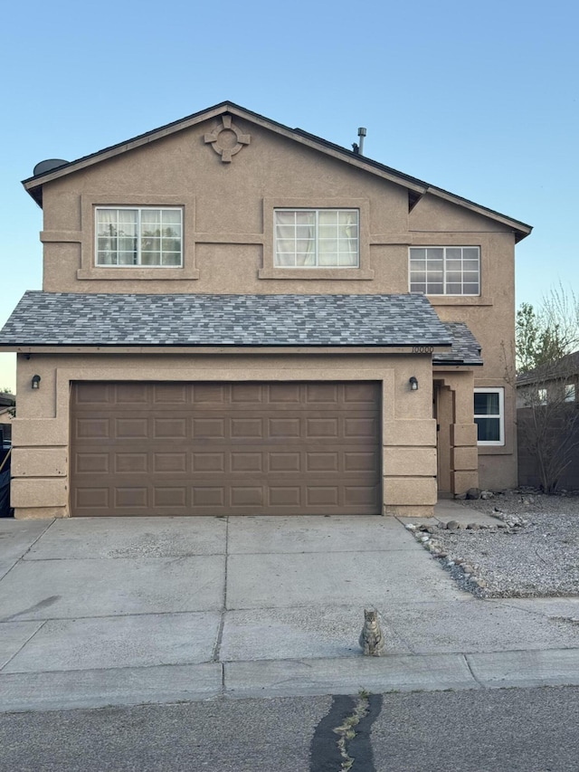 view of front of property featuring a garage, stucco siding, and concrete driveway