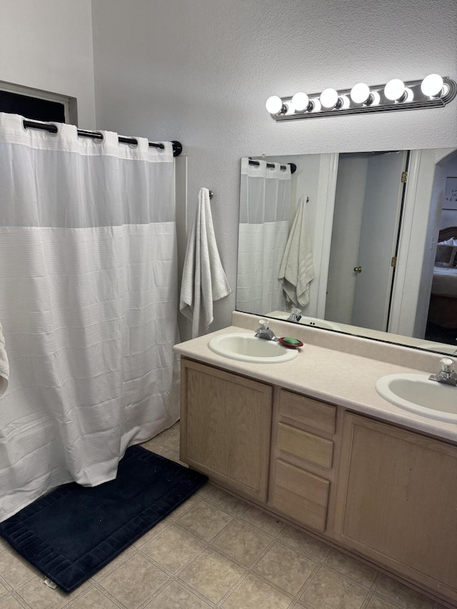 bathroom featuring a sink, a shower with curtain, and double vanity