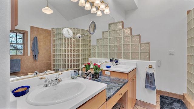 535 Cacahuate SW, Albuquerque, NM 87105 - bathroom featuring tile patterned flooring, a chandelier, vanity, vaulted ceiling, and a walk in shower