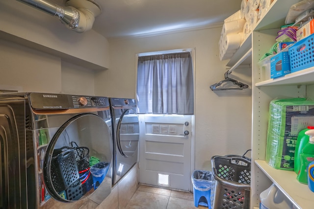 clothes washing area featuring independent washer and dryer, laundry area, and tile patterned floors