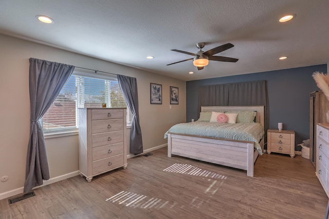 bedroom with visible vents, recessed lighting, baseboards, and wood finished floors