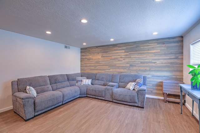 living area featuring visible vents, recessed lighting, a textured ceiling, and wood finished floors