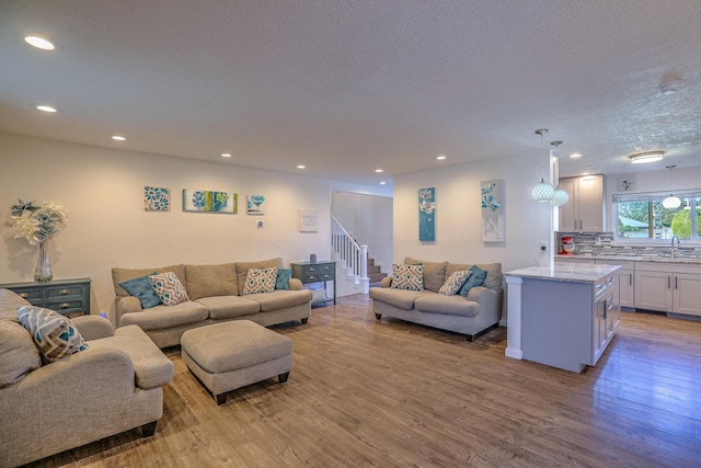 living room with stairway, recessed lighting, and light wood finished floors