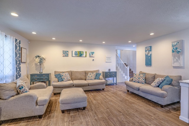 living room with recessed lighting, wood finished floors, and stairway