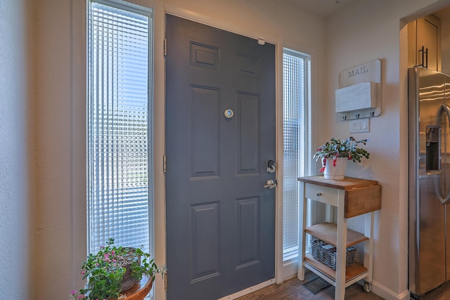 foyer entrance with baseboards and wood finished floors