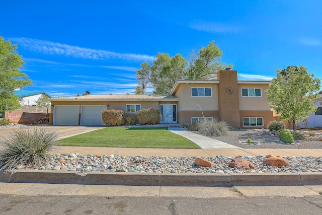 split level home with an attached garage, stucco siding, driveway, and a front yard