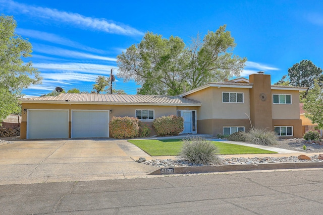 view of front of house with driveway, metal roof, a garage, a front lawn, and stucco siding
