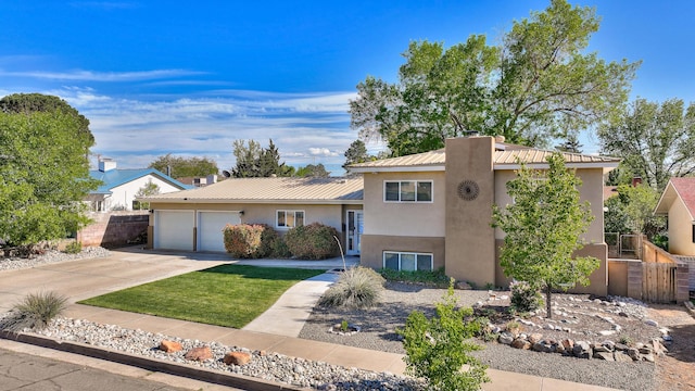 view of front of house with metal roof, fence, concrete driveway, an attached garage, and stucco siding