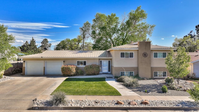 split level home featuring a garage, stucco siding, metal roof, and concrete driveway