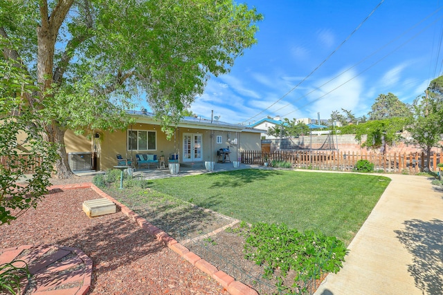 view of yard featuring fence, a patio area, and french doors