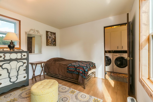 bedroom featuring washer and dryer, baseboards, and wood finished floors