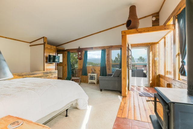 bedroom featuring a wood stove, access to exterior, vaulted ceiling, and ornamental molding