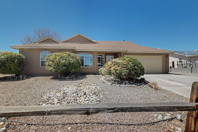 ranch-style house featuring an attached garage, stucco siding, fence, and concrete driveway