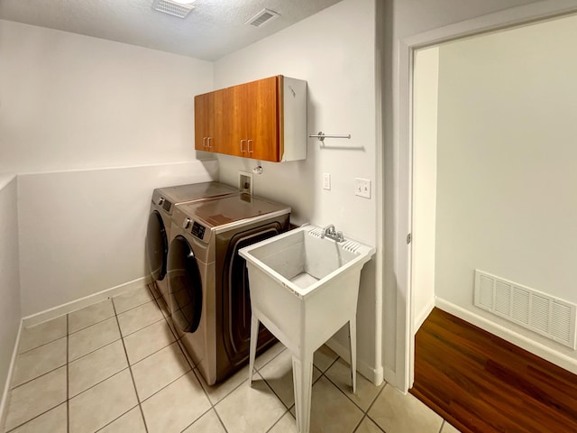 2009 Alama Dr NE, Rio Rancho, NM 87124 - clothes washing area with visible vents, baseboards, cabinet space, and light tile patterned floors