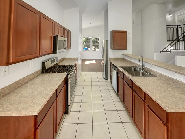 2009 Alama Dr NE, Rio Rancho, NM 87124 - kitchen featuring a sink, light countertops, stainless steel appliances, a peninsula, and light tile patterned floors