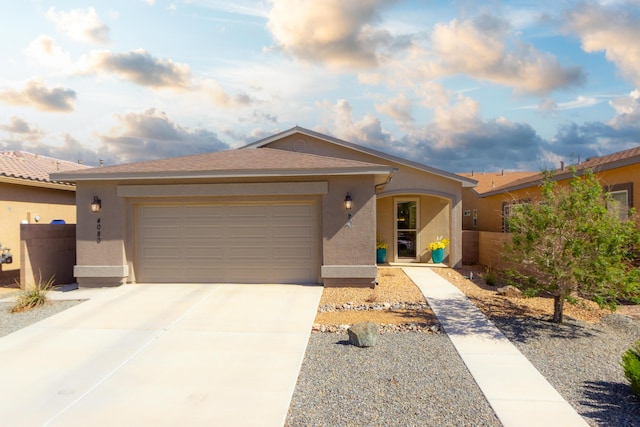 view of front of property featuring concrete driveway, a garage, fence, and stucco siding