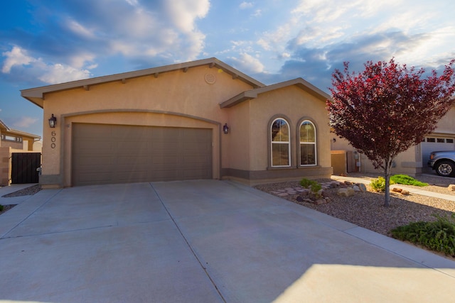 view of front of home featuring an attached garage, stucco siding, and driveway