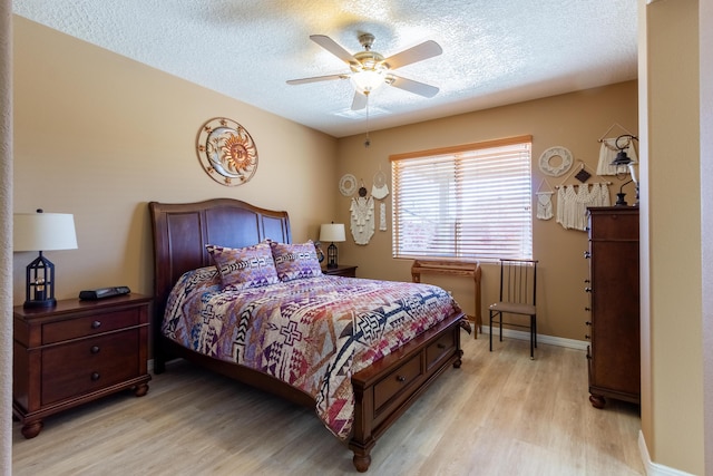 bedroom featuring light wood-type flooring, a textured ceiling, and baseboards