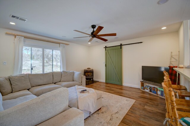 living area featuring ceiling fan, visible vents, wood finished floors, a barn door, and recessed lighting
